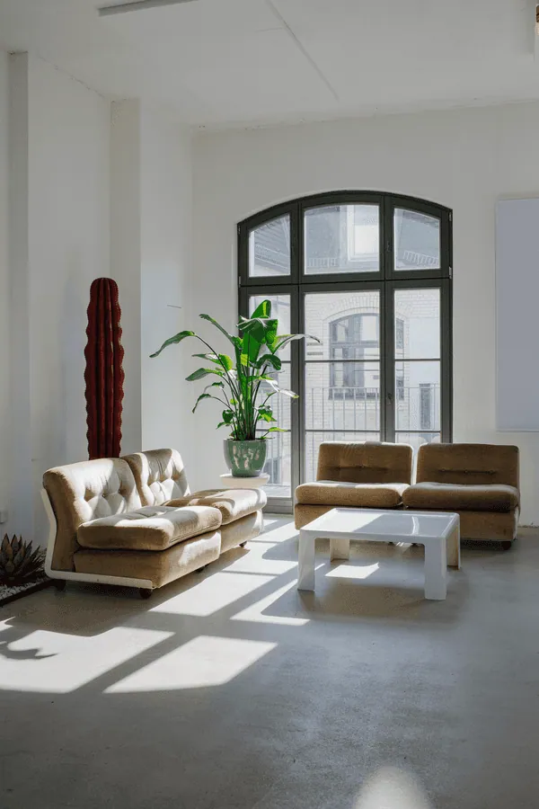Sun-filled lounge with sofas and tall windows